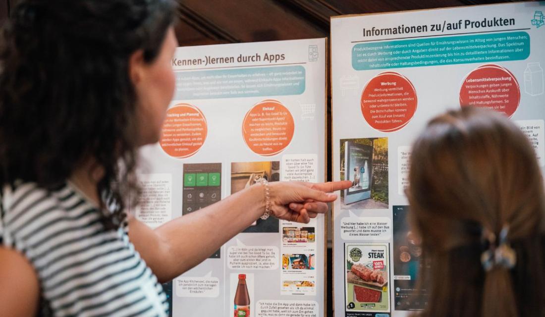 Personen schauen sich ein Aufklärungsplakat an.